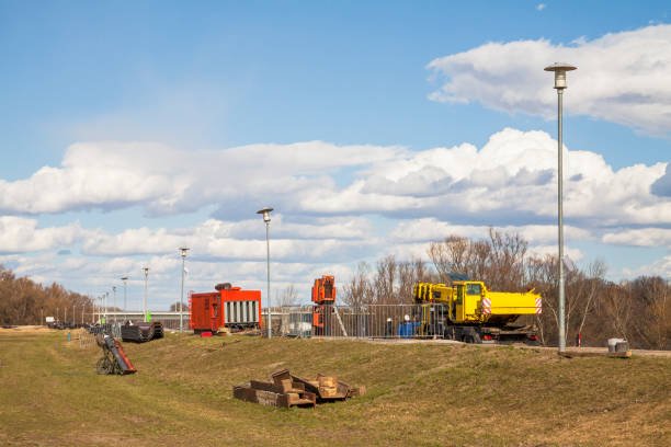 Flood protection dam under construction on river Danube with crane and genset.